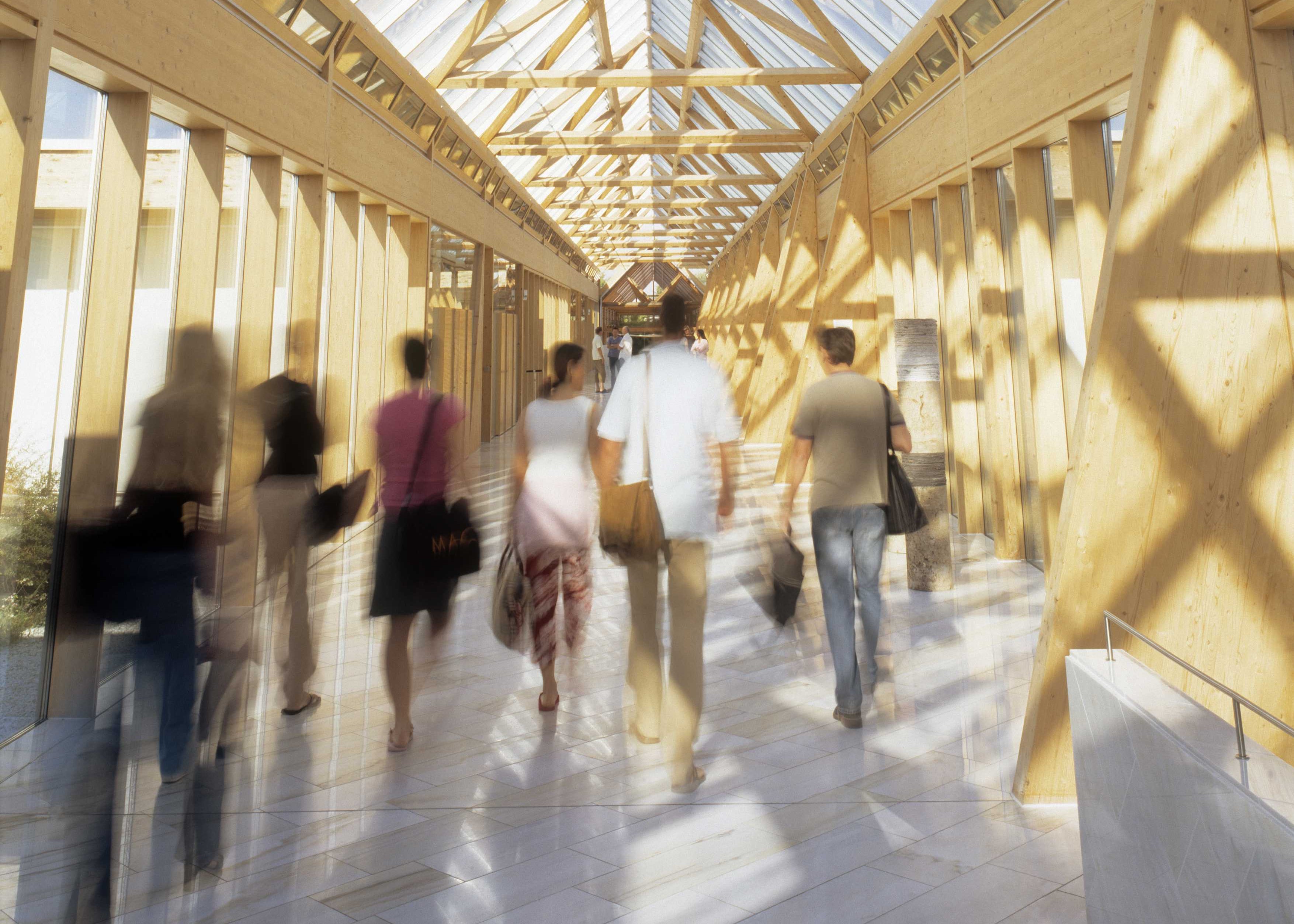 Mitarbeiter laufen durch lichten Gang